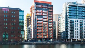 A modern building with multiple floors, large windows, and balconies. - Clover Court by Aeria Apartments (London)