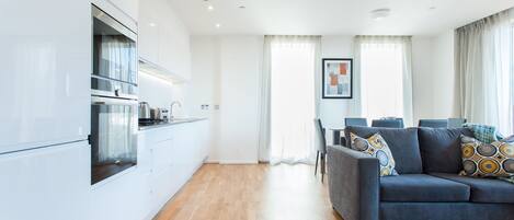 A modern apartment with a kitchen, dining area, and living room.