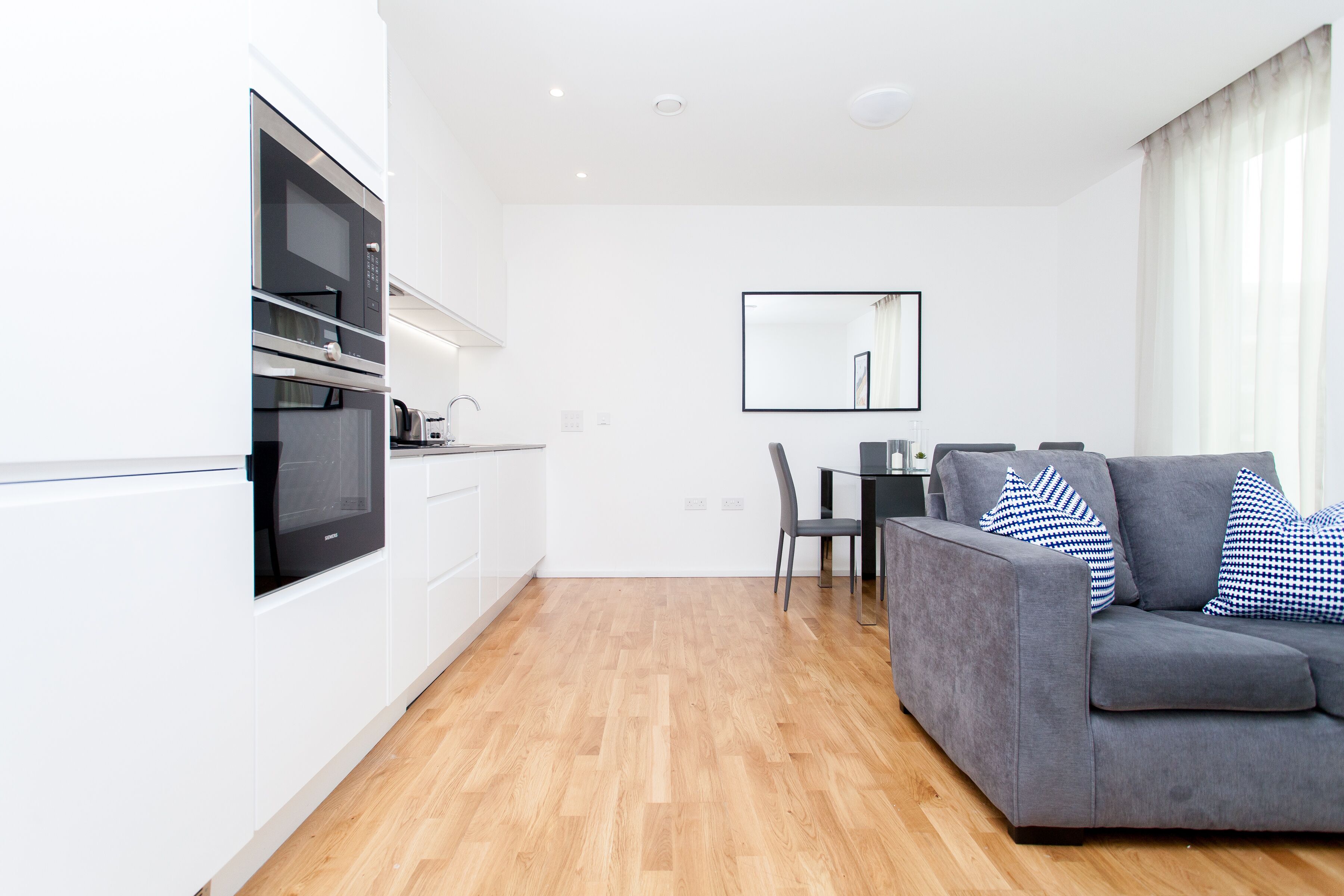 A modern apartment with a kitchen, dining area, and living room.