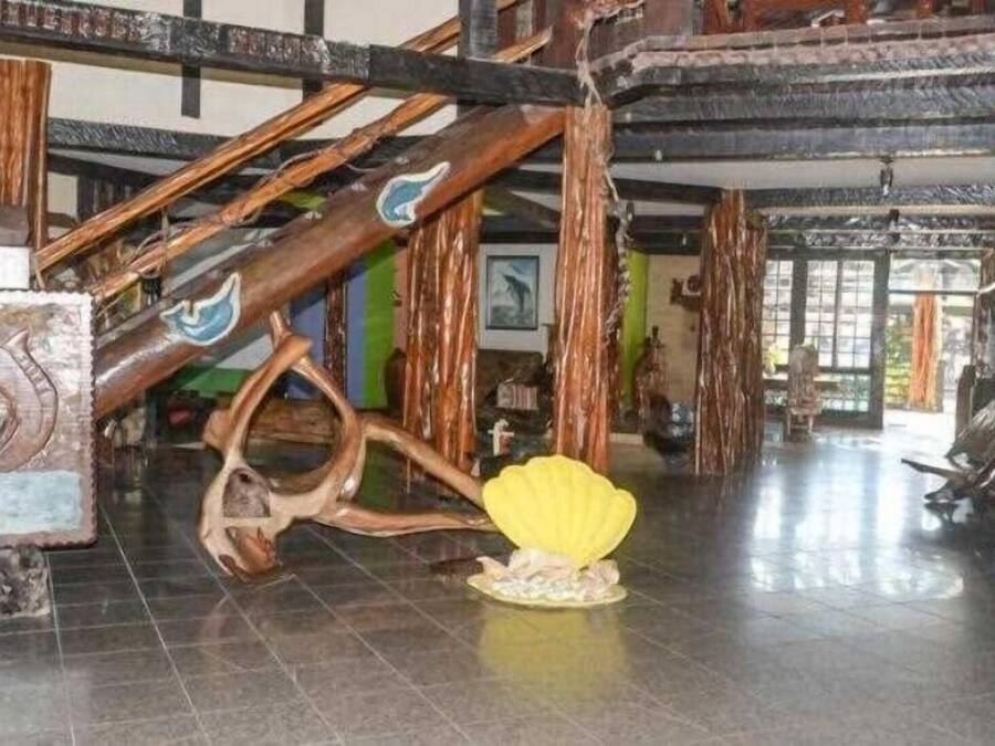 Un interior espacioso con techo alto y vigas de madera a la vista.