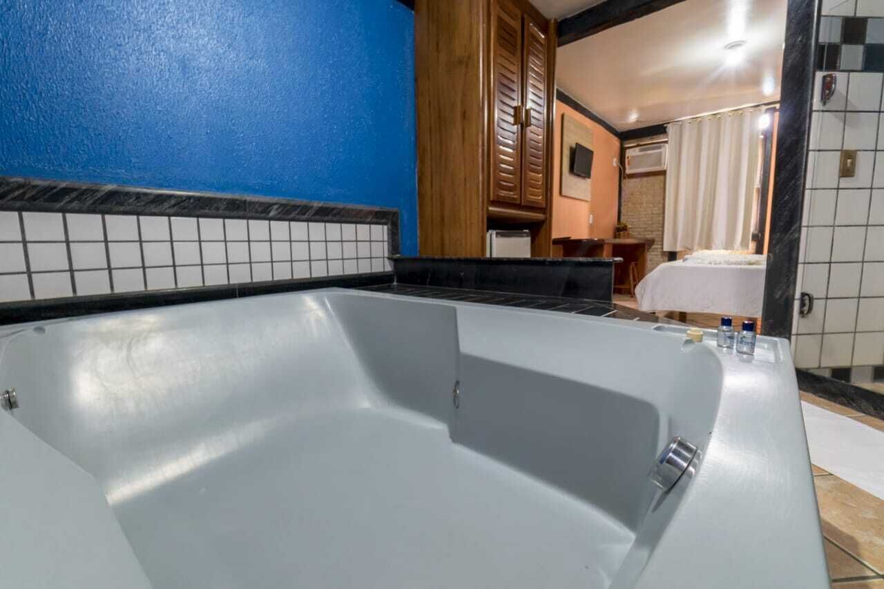Uma casa de banho moderna com uma banheira grande, uma parede azul e chão em mosaico.