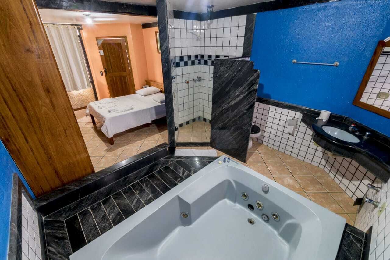 A bathroom with a large bathtub, a shower, and a sink.