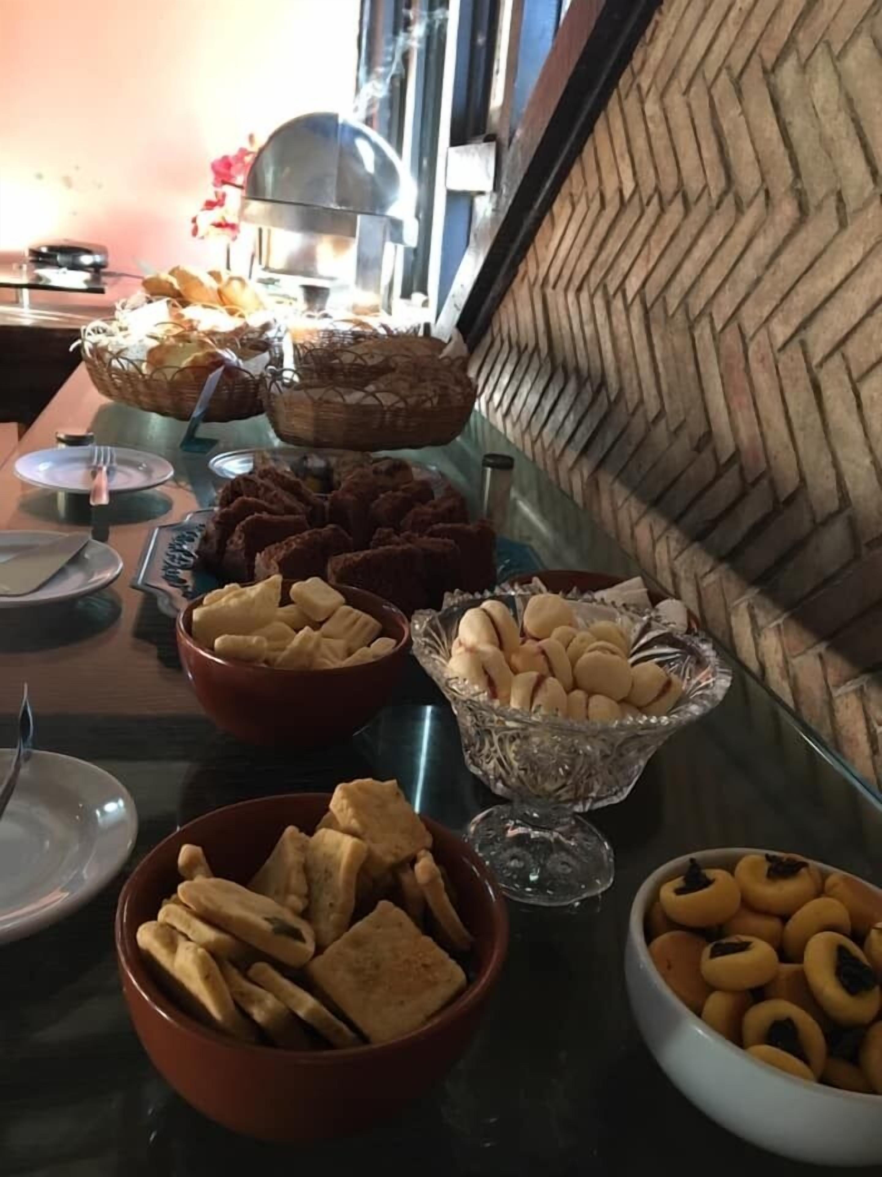 A buffet table with various food items including bread, pastries, and cookies.