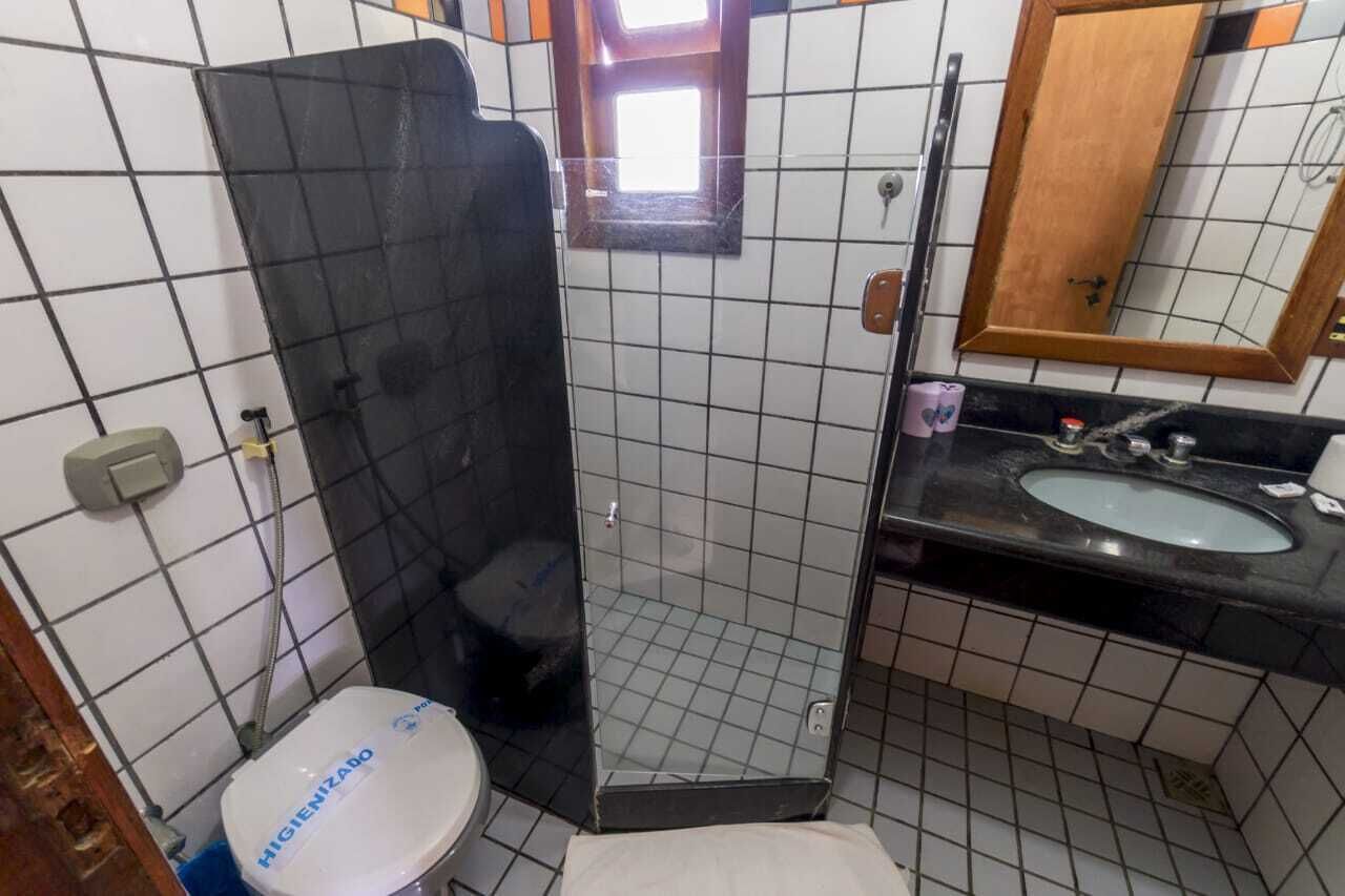 Un baño pequeño con inodoro, lavamanos e insonora de ducha.