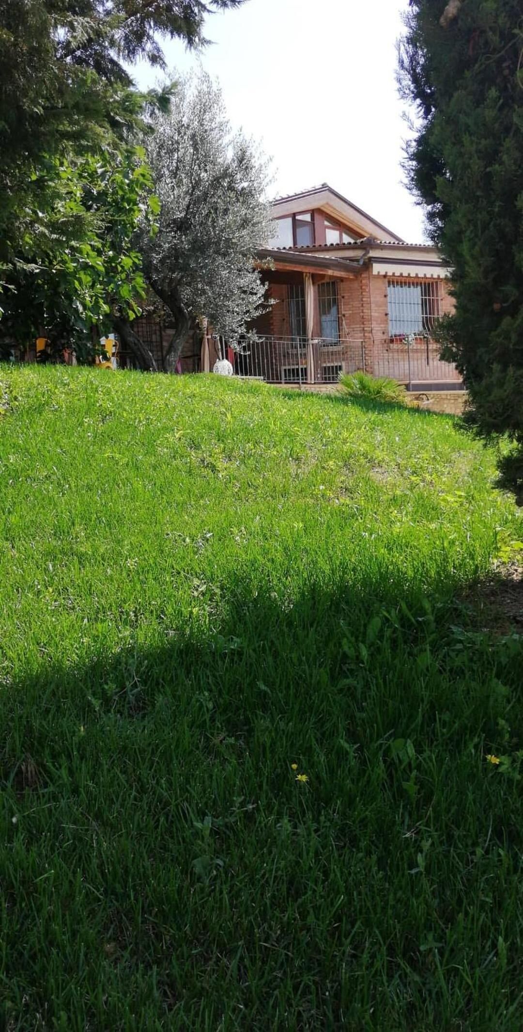 A house with a brick exterior, a front porch, and a fenced yard.