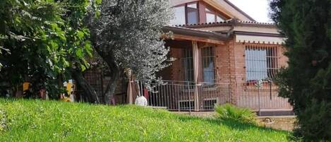 A house with a brick exterior, a front porch, and a fenced yard.