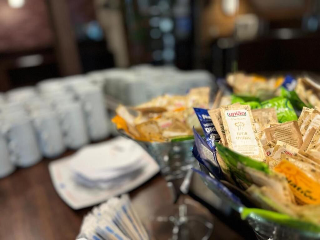 A table with various packaged snacks and a glass of wine.