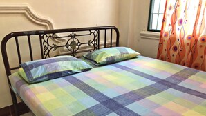 Un lit avec une couvre-lit à carreaux colorés et deux oreillers.