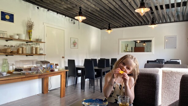 Ruokailutila, jossa on puinen pöytä, tuoleja ja tiskitaso, jossa on tarjolla ruokaa.