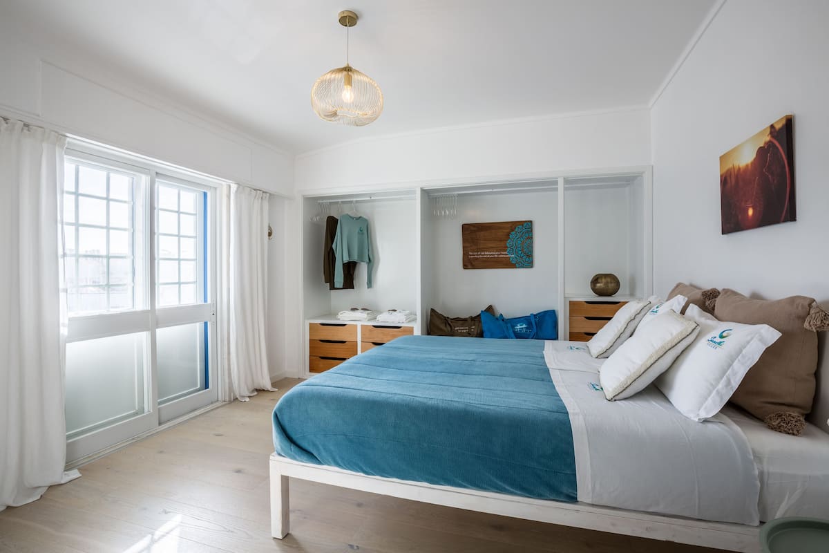 Ein Schlafzimmer mit einem Bett, einem Schreibtisch und einem Fenster.