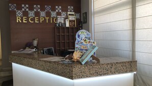 A reception desk with a 'RECEPTION' sign, a decorative wall with patterned tiles, and a 'Planet Ocean' themed poster. - Salena Beach Hotel (Primorsko)