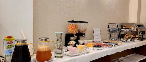 A breakfast buffet with various food items and beverages.