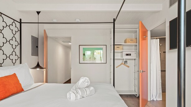A modern hotel room with a bed, a wardrobe, a mirror, and a picture on the wall. - The Weekend by AvantStay (Palm Springs)