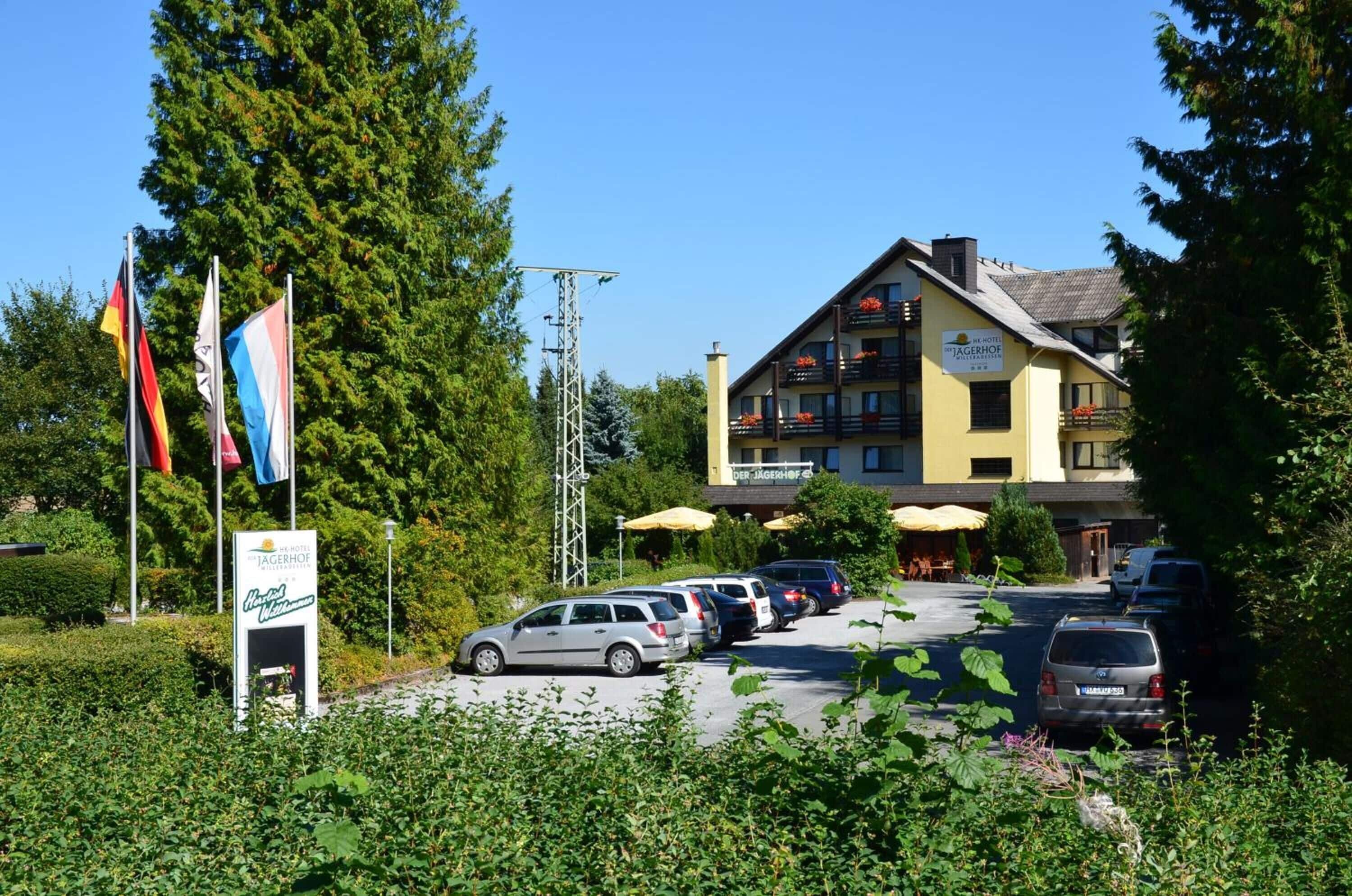 A hotel with multiple floors, outdoor seating, and flags.