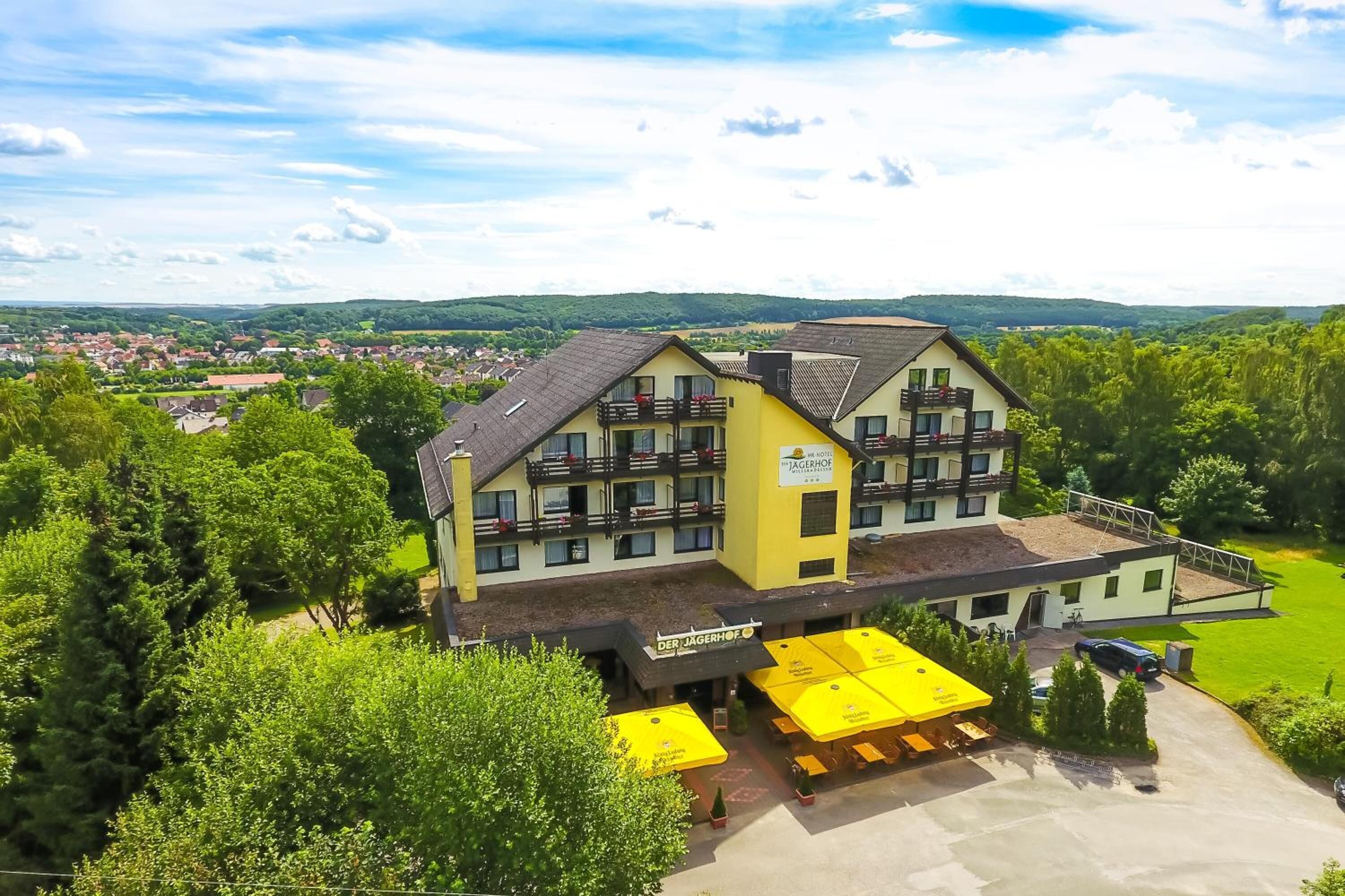 A yellow building with balconies and a sign reading "DER JAGERHOF".