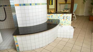 Ein Badezimmer mit einem Waschbecken, einer Badewanne und einer Duschkabine.