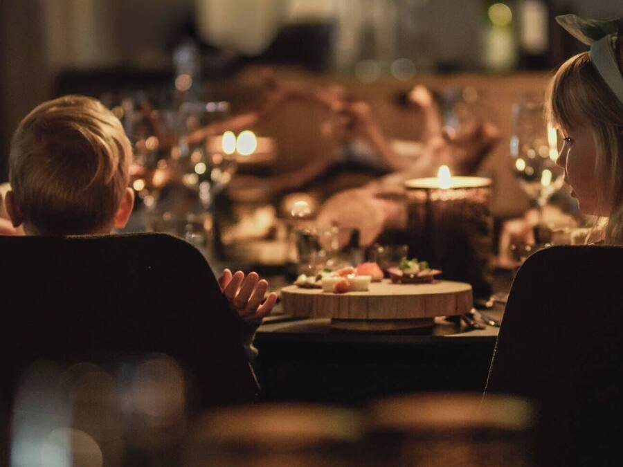 A dimly lit dining area with a round table set for a meal.
