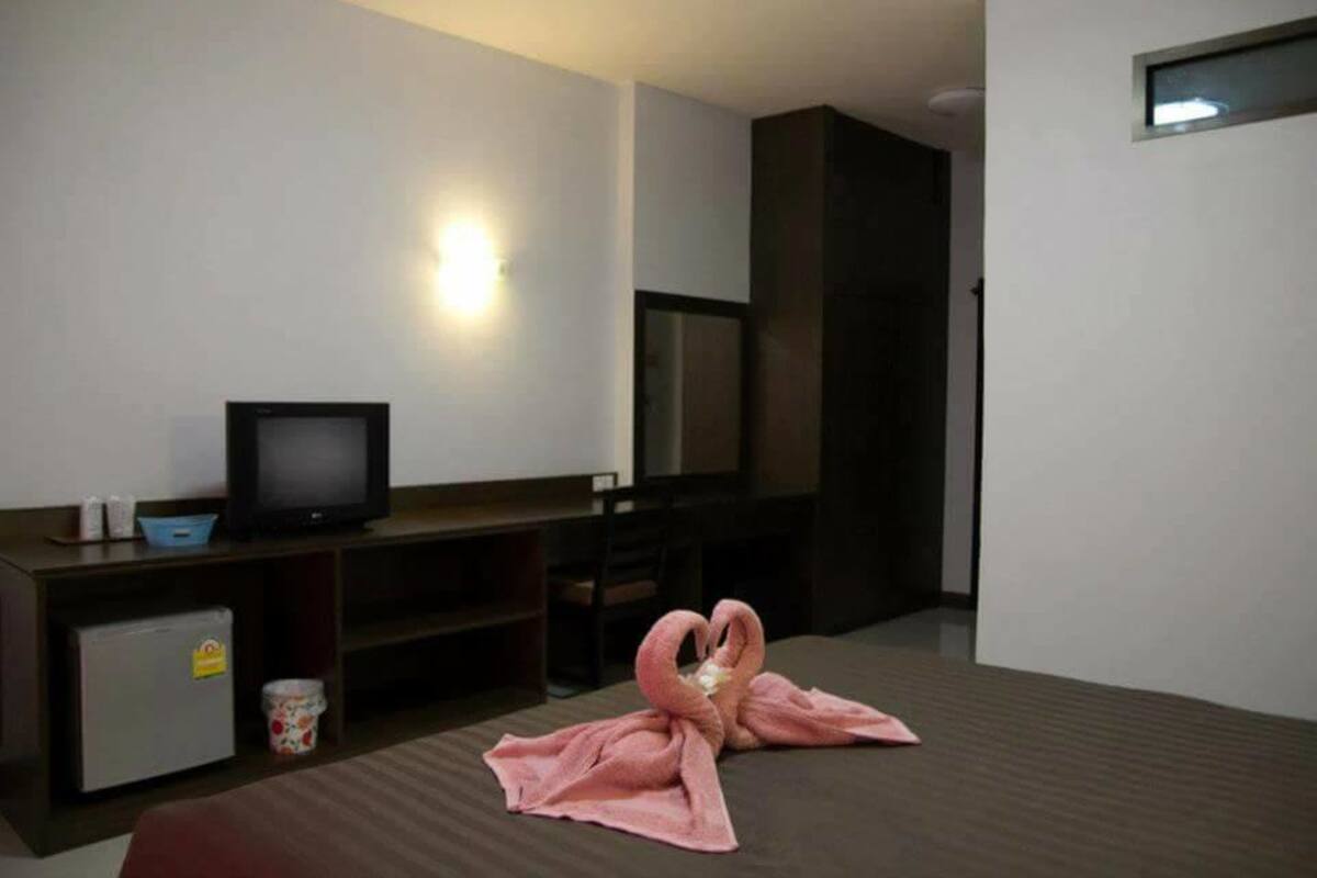 Een hotelkamer met een bed, een televisie, een kleine koelkast en een magnetron.