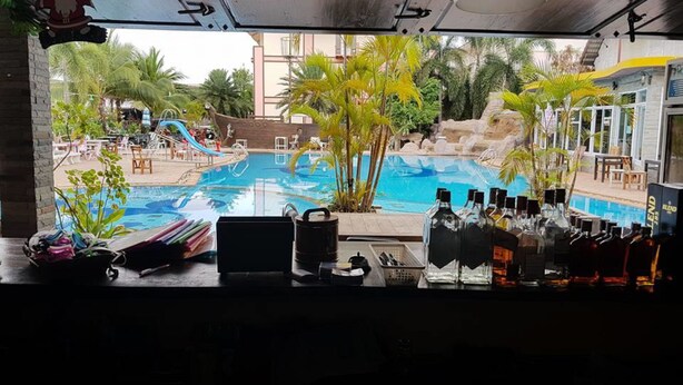 Un espace bar avec vue sur la piscine, du matériel de bar et des sièges en plein air.