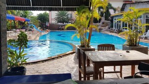 Une piscine extérieure avec des chaises longues et un espace salon abrité.