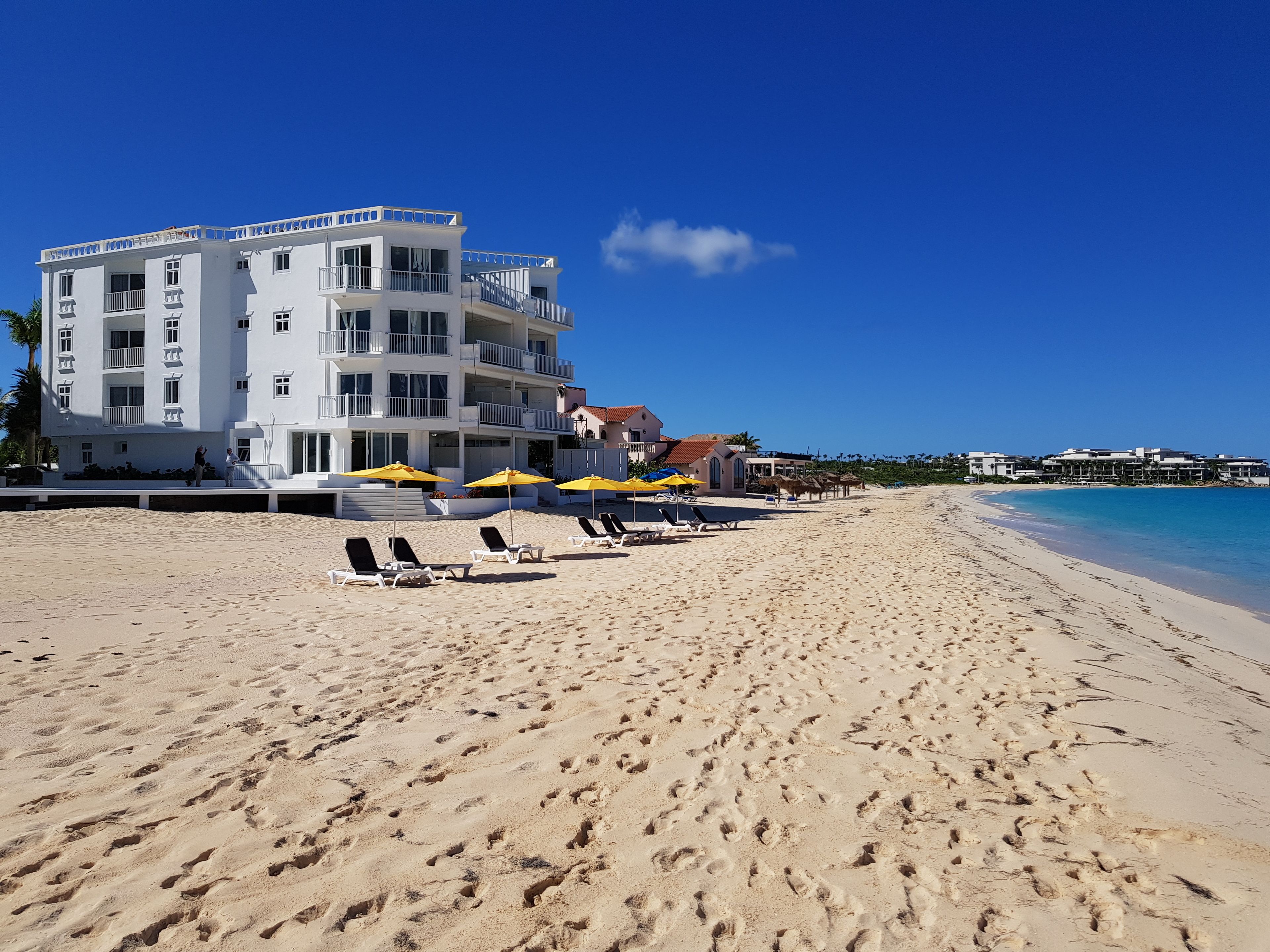 On the beach, white sand, sun-loungers, beach umbrellas