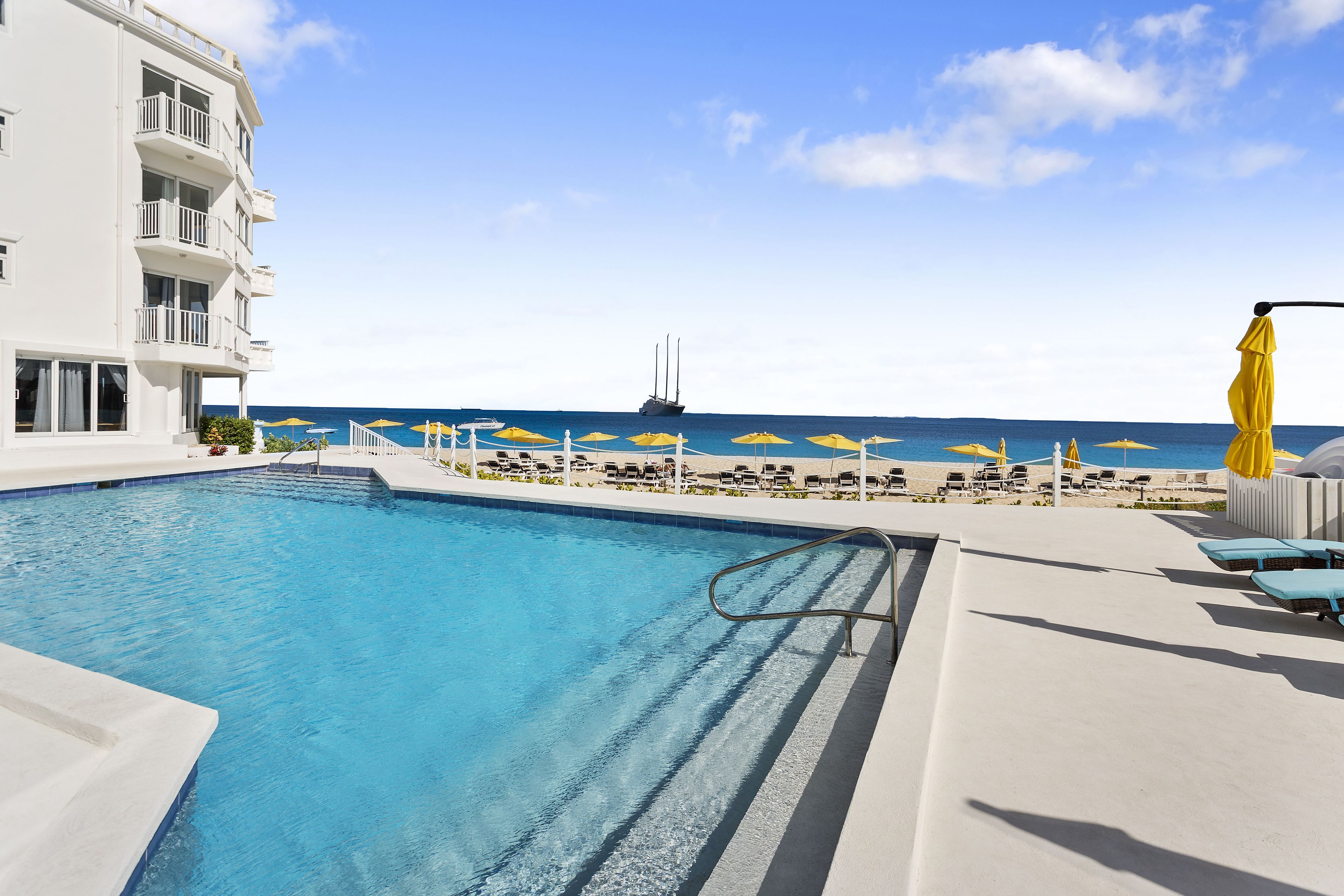 Una piscina al aire libre, sillones reclinables de piscina