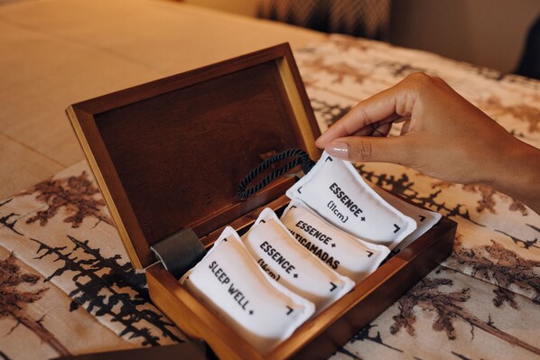 A wooden box with compartments containing items labeled 'ESSENCE' and 'SLEEP WELL'.