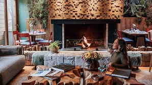 A cozy living room with a fireplace, wooden furniture, and a comfortable seating area. - Wood Hotel Gramado (Gramado)