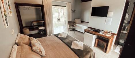 Un dormitorio con cama, escritorio, silla y televisión.