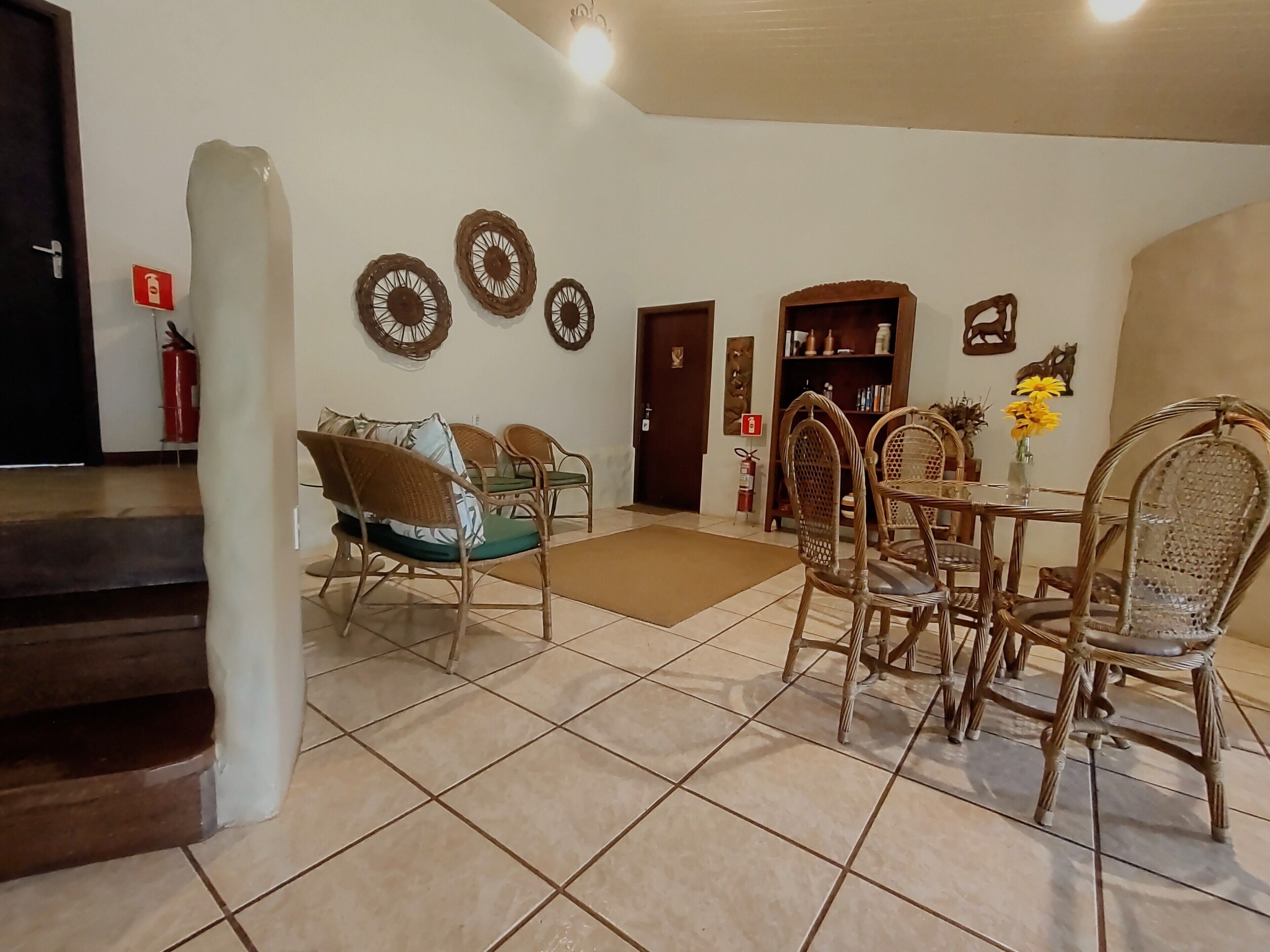 Un amplio espacio de sala con una mesa de comedor y sillas, un sofá y una estantería.