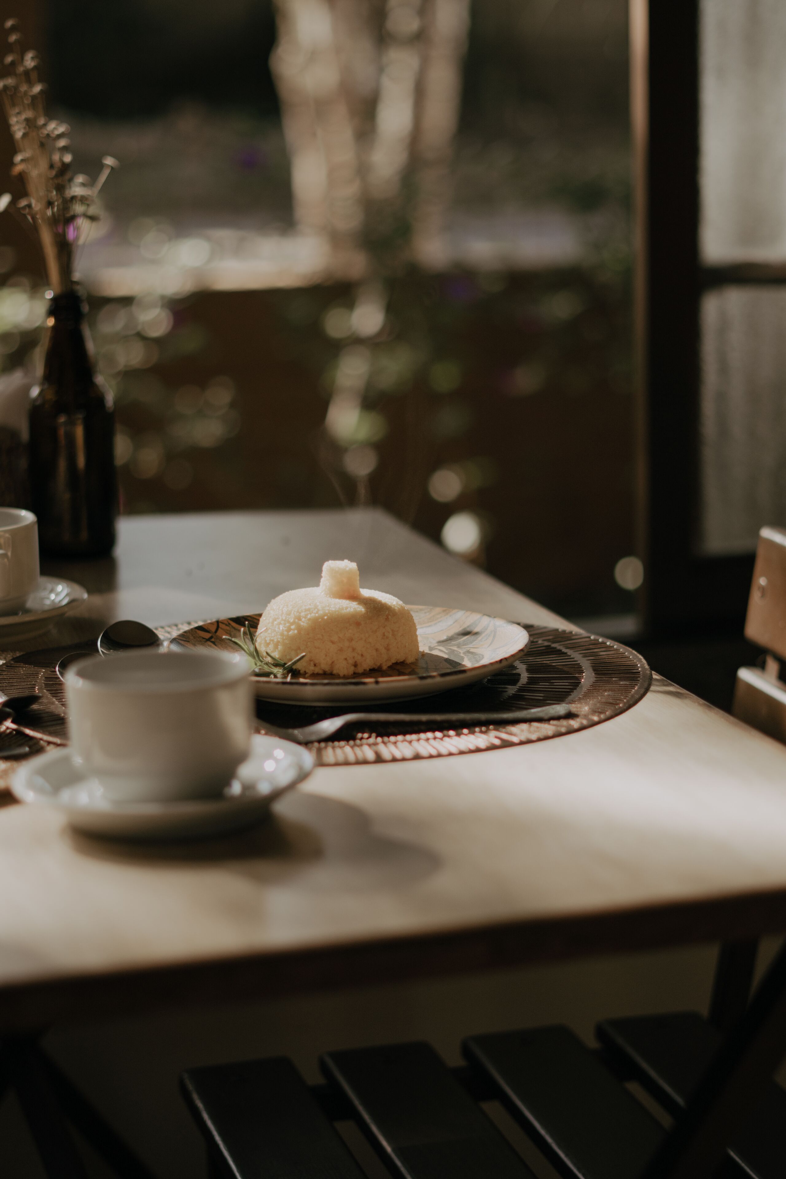 Une table avec une assiette de nourriture, une tasse et une bouteille.
