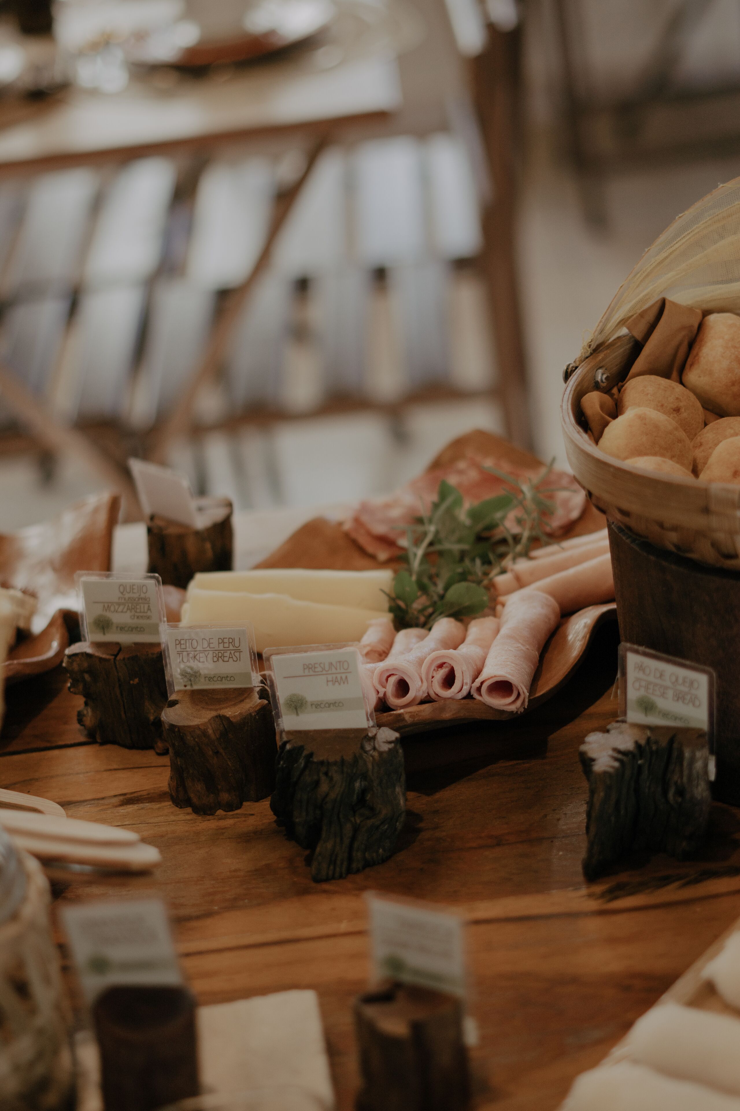 Una mesa de madera con diversos alimentos y etiquetas, incluyendo carnes y quesos.