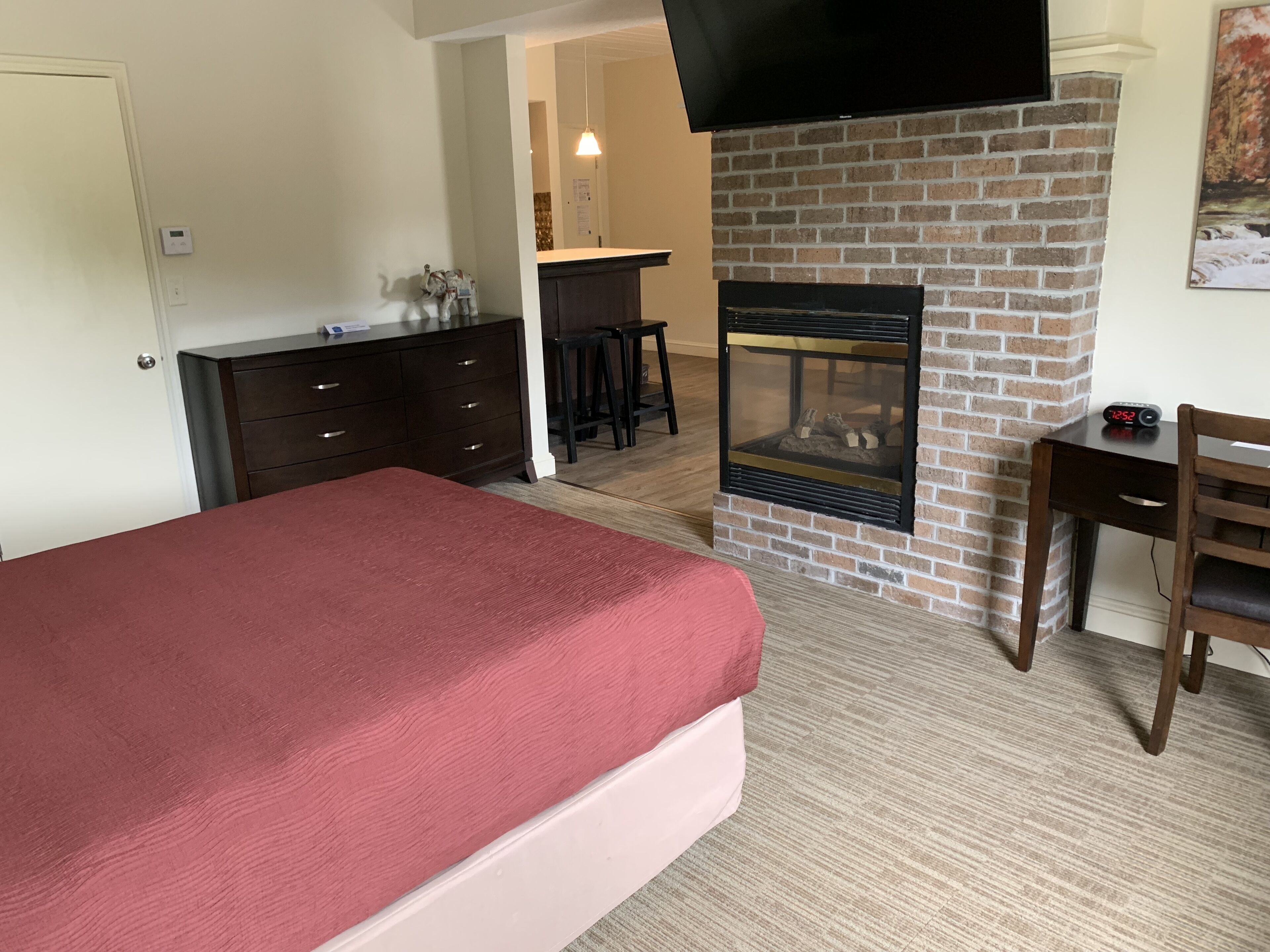 Une chambre d’hôtel avec un lit, une cheminée, un bureau et une télévision.