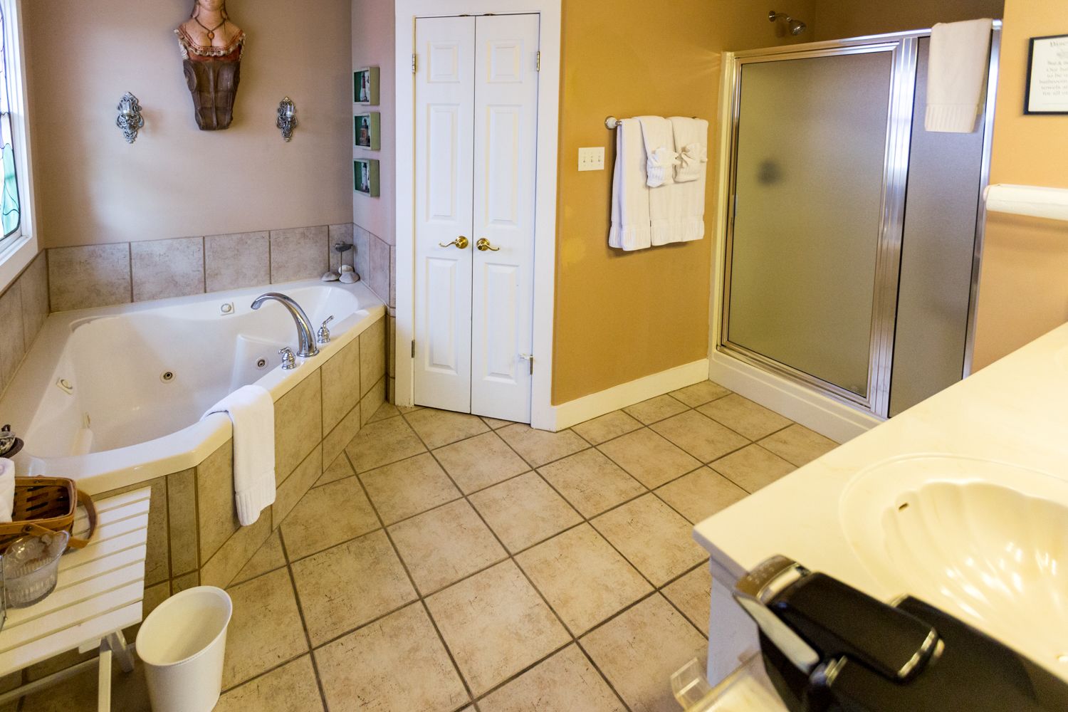 A bathroom with a bathtub, a shower, a sink, and a vanity.