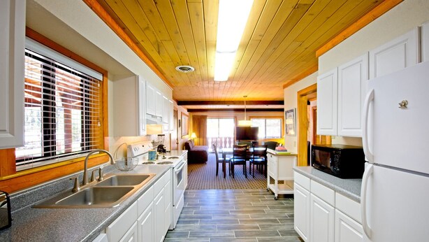 Una cocina moderna con armarios blancos, encimeras de granito y una isla central.