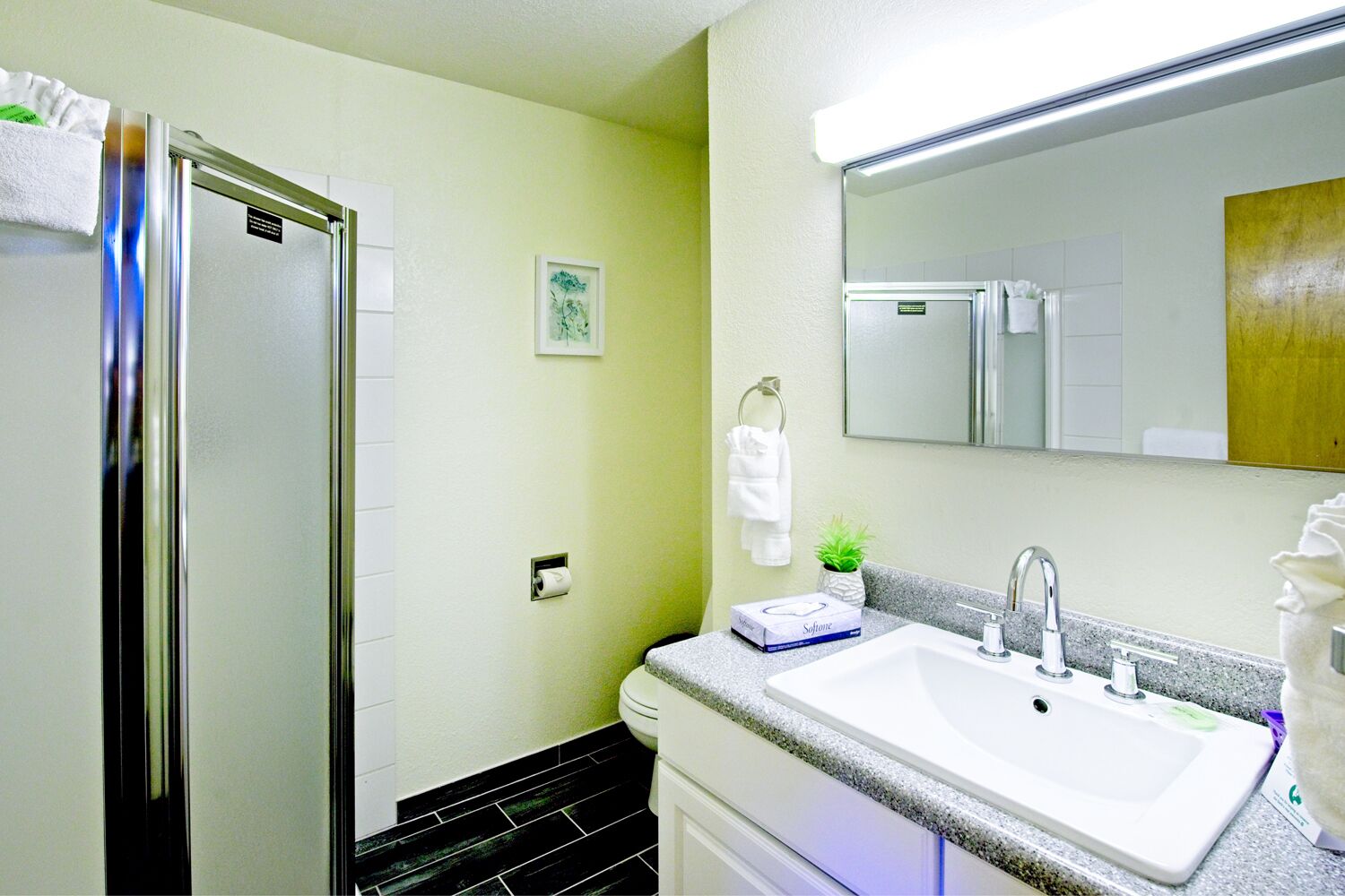 A bathroom with a white sink, a mirror, a towel rack, and a toilet.