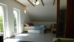 Un'ampia stanza con un letto, una scrivania e una sedia. Sono presenti ampie finestre e una porta.