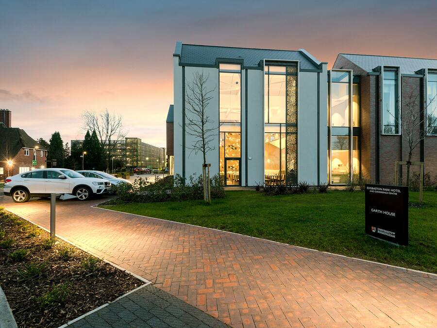 Un edificio moderno con entrada pavimentada, un letrero que indica 'EGGSTON PARK HOTEL AND CONFERENCE CENTRE' y un coche blanco estacionado al frente.