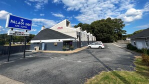 A hotel named "Palace Inn and Suites" with a sign indicating it is now open 24/7. - Jefferson Inn and Suites (Newport News)