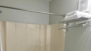 A bathroom with a bathtub, toilet, and a towel rack. - Jefferson Inn and Suites (Newport News)