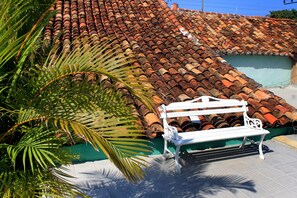 A tiled roof, a bench, and a palm tree. - Casa Lyosman y Yanin (Trinidad)