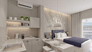 A modern hotel room with a kitchenette, a bed with a blue headboard, a dining table with benches, and a large window with a view. - Great Living Koukaki (Athens)