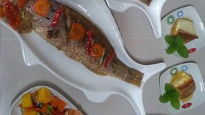A meal with two whole fish, a fruit salad, and roasted vegetables. - El Jardín de Daynelis (Viñales)
