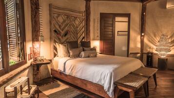 Un dormitorio con una cama de madera, un banco, una mesita de noche y una lámpara.