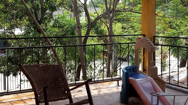A covered outdoor seating area with a table, chairs, and a children's slide. - El Huastequito (Ciudad Valles)