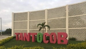 A sign with the word 'TANTOCOR' in large letters, set against a lattice fence with a palm tree in front. - El Huastequito (Ciudad Valles)