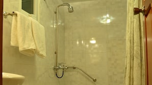 Casa de banho com sanita, bidé e cabine de duche.
