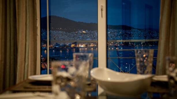 A dining table with a view of a cityscape at night. - Nice Greek Villa (Kavala)