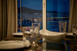 A dining table with a view of a cityscape at night. - Nice Greek Villa (Kavala)