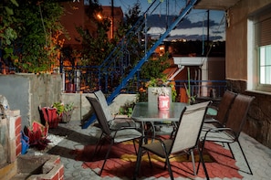An outdoor patio with a table and chairs, surrounded by potted plants and a blue staircase. - Nice Greek Villa (Kavala)